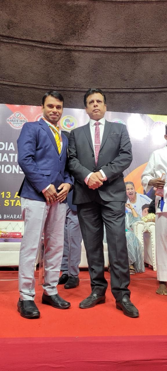 Coach medal stage pose with official
