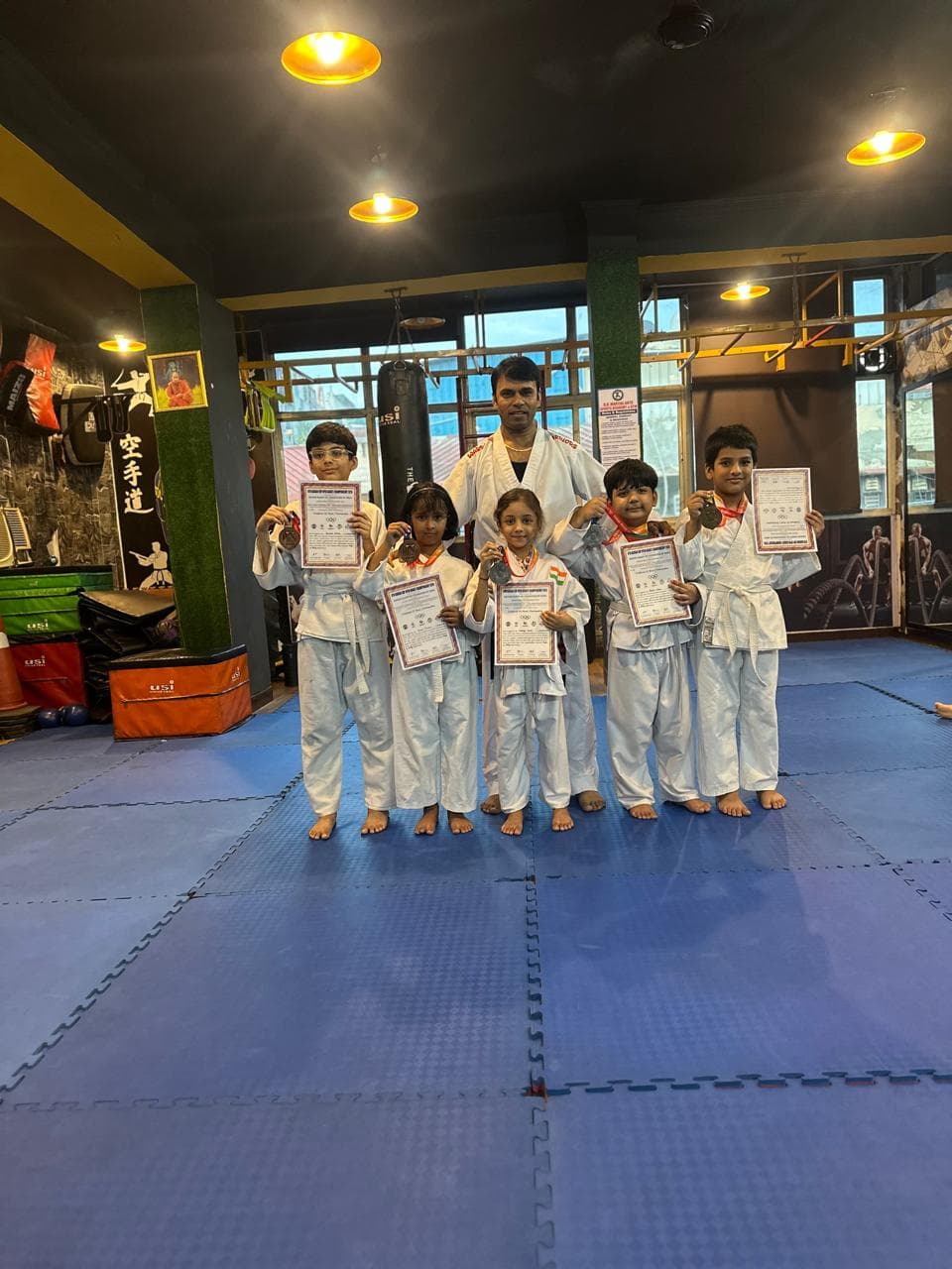Young martial arts students posing with their instructor