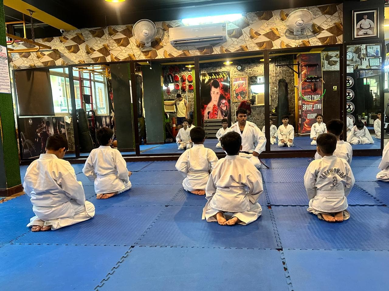 Martial arts instructor teaching children in class