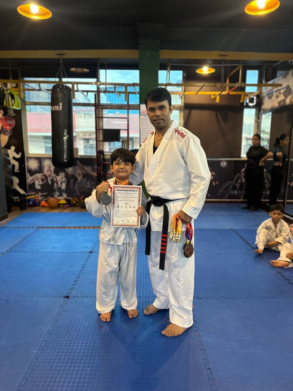 Young martial arts student posing with the instructor