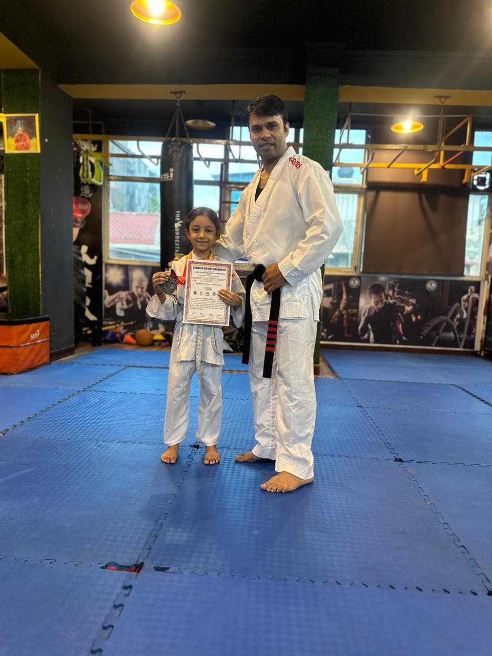 Martial arts coach posing with a young student
